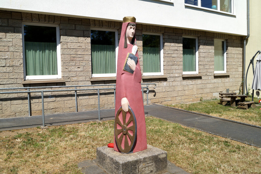 Eine Statue der Heiligen Katharina von Alexandrien steht vor dem Eingang der Kita in Kernscheid.